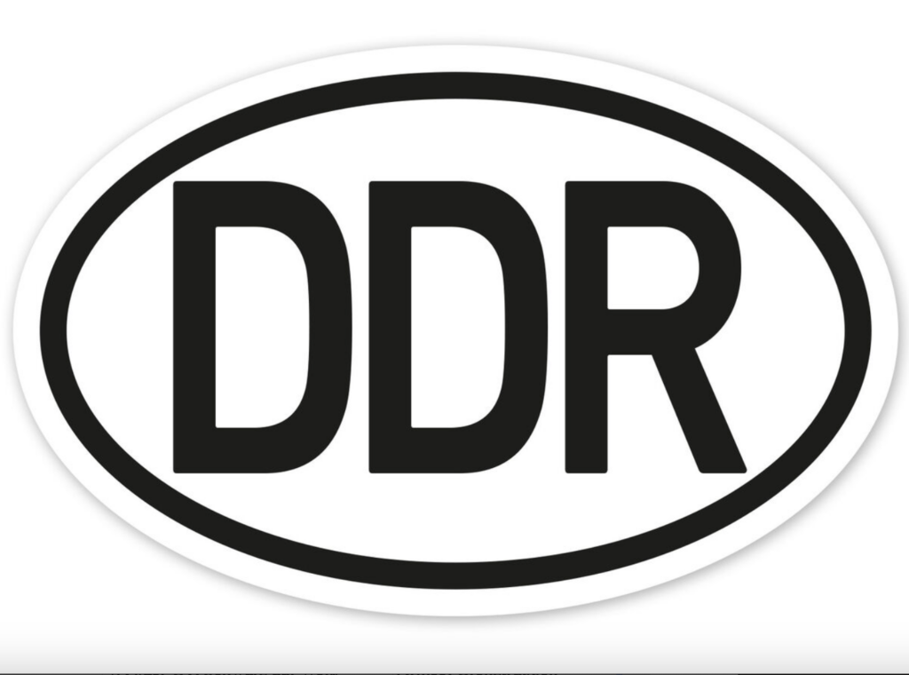 Schwarz-weißes DDR-Logo mit ovaler Umrandung, symbolisch für historische Kennzeichen und die Deutsche Demokratische Republik.